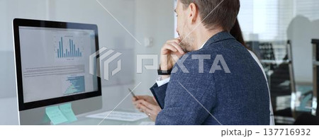 Business colleagues analyzing financial data on computer, discussing project statistics and market trends in office meeting. Businesspeople concept Business colleagues analyzing financial data on computer, discussing project statistics and market trends in office meeting. Businesspeople concept 137716932