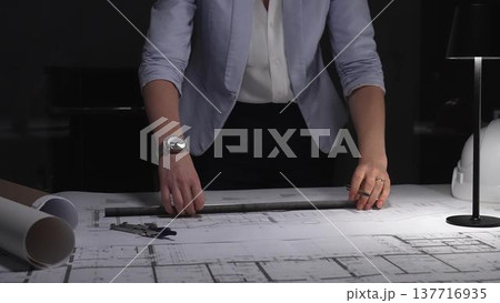 Female architect working on blueprints, measuring building plans at night, designing new construction project. Business and architect people concept Female architect working on blueprints, measuring building plans at night, designing new construction project. Business and architect people concept 137716935