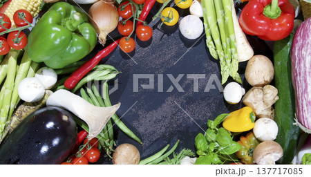 Fresh vegetables arranged on a dark surface for a recipe preparation scene in a kitchen during daytime 137717085