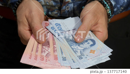 Currency exchange for local and foreign money in hands shows cash in different banknotes with face value Currency exchange for local and foreign money in hands shows cash in different banknotes with face value 137717140