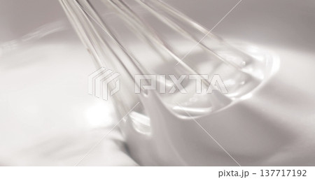 Whisk mixes egg whites in a clear bowl during a baking session in a kitchen on a sunny afternoon 137717192
