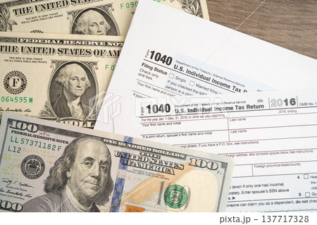 Tax form 1040 U.S. Individual Income Tax Return with dollar banknotes money. 137717328