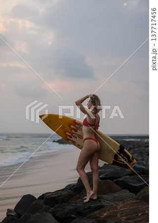 Beachside Surfer Enjoying Evening Sky. Evening Beach Surfer Gazing At Vibrant Sunset Colors In Sky Beachside Surfer Enjoying Evening Sky. Evening Beach Surfer Gazing At Vibrant Sunset Colors In Sky 137717456