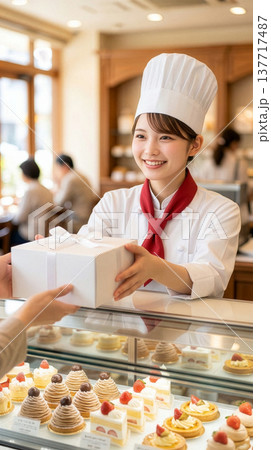 お客様にケーキを手渡す女性店員 137717487