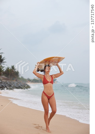 Confident Woman In Sunny Surf. Caucasian Woman Confidently Walks Towards Ocean Waves Along Beach Confident Woman In Sunny Surf. Caucasian Woman Confidently Walks Towards Ocean Waves Along Beach 137717540