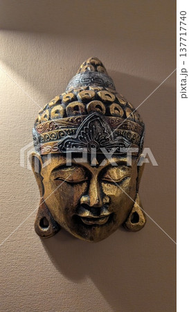 Elegant antique brass Buddha mask with detailed craftsmanship display 137717740