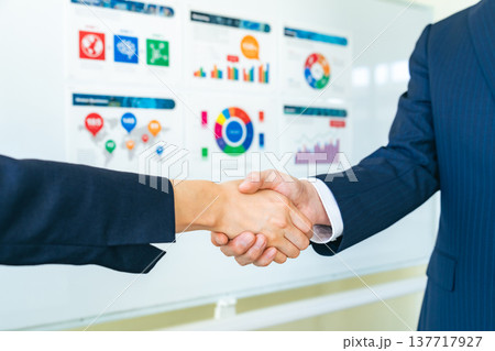 商談をして握手するビジネスパーソンのグループ 137717927