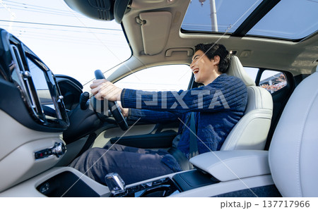 笑顔で自動車を運転する男性ドライバーの車内写真 137717966