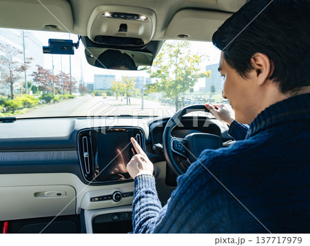 自動車のインパネ画面をタッチするドライバー 137717979