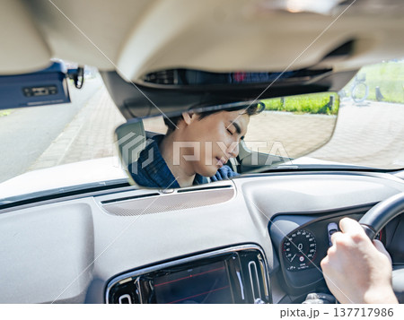 居眠り運転する男性ドライバーのルームミラー越しの表情 居眠り運転する男性ドライバーのルームミラー越しの表情 137717986