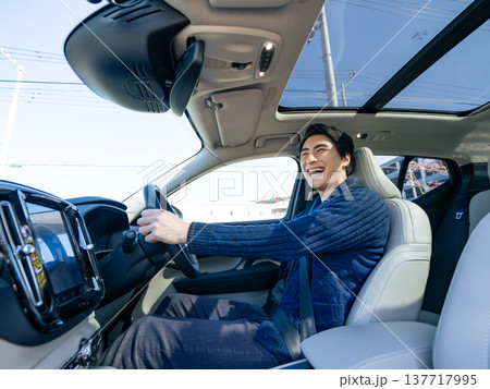 笑顔で自動車を運転する男性ドライバーの車内写真 137717995