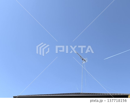 屋根の上のテレビアンテナと飛行機雲 137718156