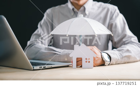 Business man demonstrating home insurance concept, protecting house property model with umbrella, illustrating financial security and mortgage safeguard protection for residence Business man demonstrating home insurance concept, protecting house property model with umbrella, illustrating financial security and mortgage safeguard protection for residence 137719251