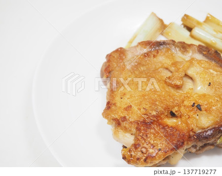 余白のある構図の鶏もも肉ソテーと長ねぎ 137719277