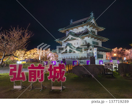 大きな文字の看板が置かれたフォトスポットとライトアップされた夜の城と桜の春景色 (青森県、弘前) 大きな文字の看板が置かれたフォトスポットとライトアップされた夜の城と桜の春景色 (青森県、弘前) 137719289