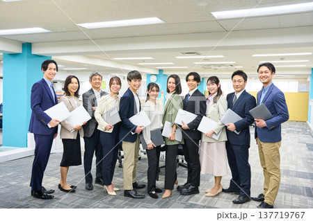 オフィスの広い空間で集合したビジネスパーソンの男女大人数 全身写真撮影 137719767
