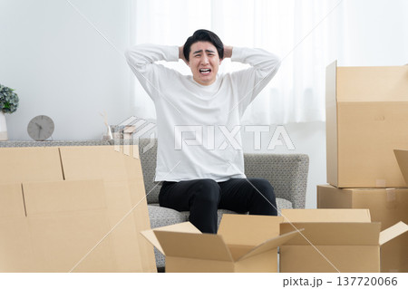 引越しの荷造りが終わらない男性(段ボール・片付け・整理) 引越しの荷造りが終わらない男性(段ボール・片付け・整理) 137720066