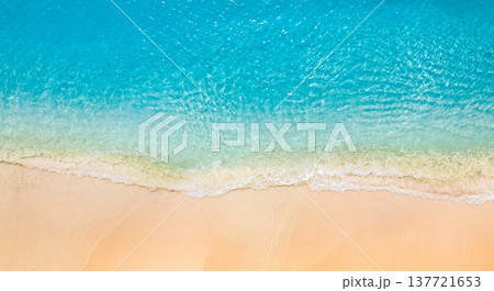 Beautiful tropical summer seascape aerial shot of crystal clear blue ocean waves lapping golden sandy beach, soft sunlight at sunset, serene and idyllic nature landscape, perfect drone view for summer 137721653
