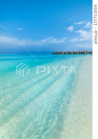 Radiant tropical ocean view with luxury overwater villas, turquoise water, serene beach, relaxing summer paradise, idyllic vacation escape 137721659