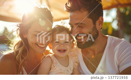 サンシェードの下で笑う家族（母親、赤ちゃん、父親） 137721938