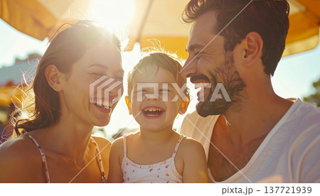 サンシェードの下で笑う家族（母親、赤ちゃん、父親） 137721939