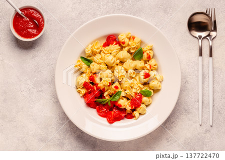 pasta in a plate with tomato sauce. 137722470