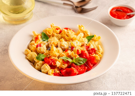 pasta in a plate with tomato sauce. 137722471