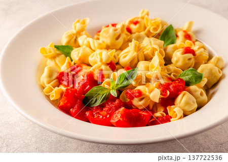 pasta in a plate with tomato sauce. 137722536
