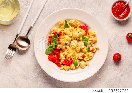 pasta in a plate with tomato sauce. 137722723