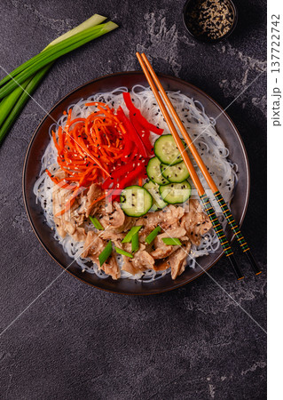 Bowl of rice noodles with vegan soy meat and vegetables. 137722742
