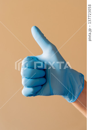 Hand wearing blue medical glove showing various gestures and signs against neutral background. Concept of hygiene, protection and communication with hand signals. Hand wearing blue medical glove showing various gestures and signs against neutral background. Concept of hygiene, protection and communication with hand signals. 137723058