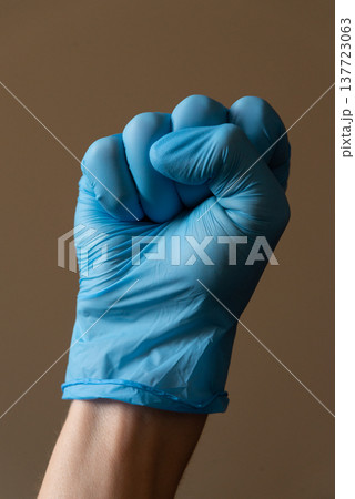Hand wearing blue medical glove showing various gestures and signs against neutral background. Concept of hygiene, protection and communication with hand signals. 137723063