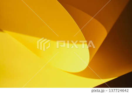 Yellow paper creating beautiful abstract pattern of curves, light and shadows Yellow paper creating beautiful abstract pattern of curves, light and shadows 137724642