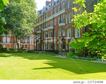 Classic victorian townhouse facade and serene private garden square Classic victorian townhouse facade and serene private garden square 137724896