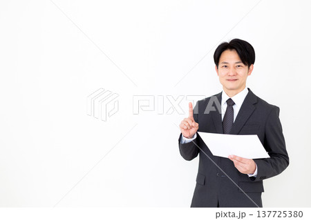 グラフを見て人差し指を立てるスーツを着たミドル男性ビジネスマン 137725380