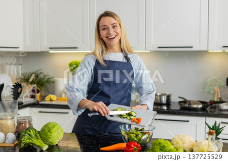 Young woman tasting keto vegetable salad recipe in home kitchen for fit healthy vegetarian nutrition 137725529
