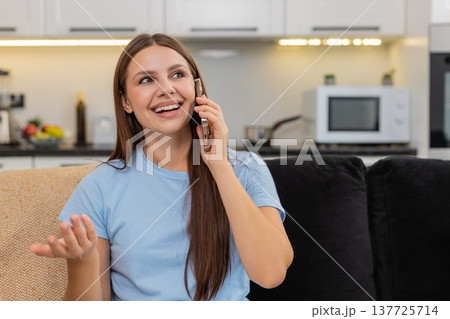 Young woman talks on smartphone dialogue enjoys voice call smiles listens with interest and energy 137725714