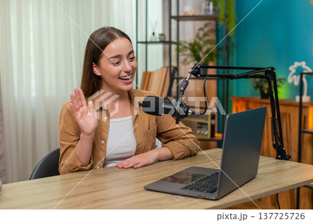 Young woman live streaming with studio microphone confidently teaching audience practical tips Young woman live streaming with studio microphone confidently teaching audience practical tips 137725726