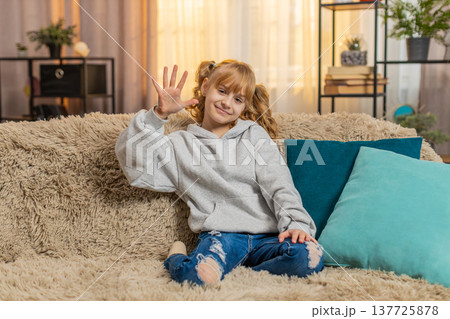 Young teenager girl waving hand with cheerful expression saying hello or goodbye indoors at home 137725878