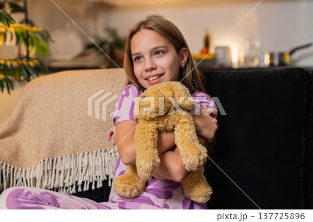 Teenager girl holds plush dog toy hugs tight smile calm cuddle sweet love soft mood cute kids vibe 137725896