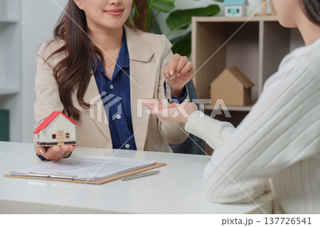 Home Purchase. Real estate agent presenting house keys to client. Home Purchase. Real estate agent presenting house keys to client. 137726541