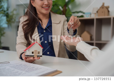 Home Purchase. Real estate agent handing over keys to new homeowner during consultation. 137726551