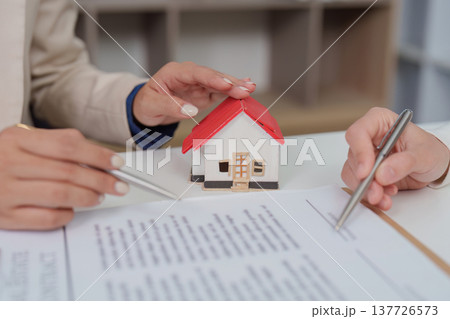 Real Estate Agreement. Agent and client discussing contract details. 137726573