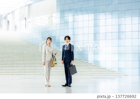 オフィスのロビーで話す若いビジネスマン 137726692