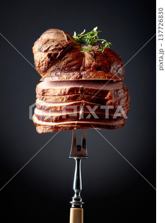Sliced smoked gammon with thyme branches on a fork. Sliced smoked gammon with thyme branches on a fork. 137726830