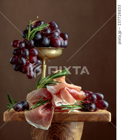Prosciutto with grapes and rosemary. 137726833