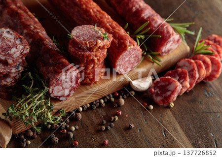 Sliced dry cured sausages with peppercorns, thyme, rosemary, and garlic. Sliced dry cured sausages with peppercorns, thyme, rosemary, and garlic. 137726852