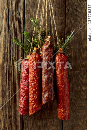 Smoked and dry cured sausages on a old wooden background. 137726857