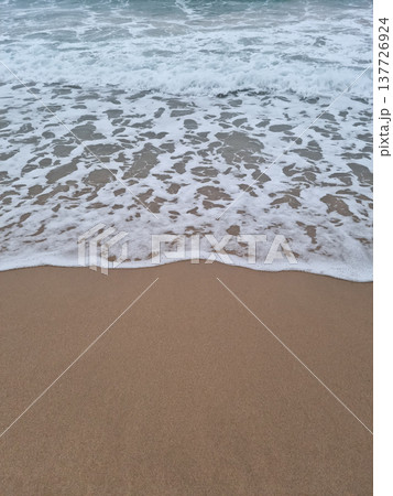 It is a beach with waves crashing in It is a beach with waves crashing in 137726924