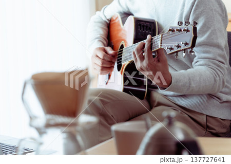 ギターを弾くミドル男性の手元 137727641